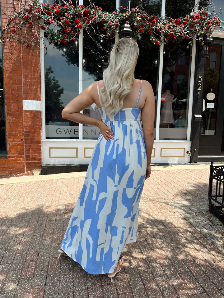 Woman wearing blue and white abstract pattern maxi dress with sweetheart neckline. 