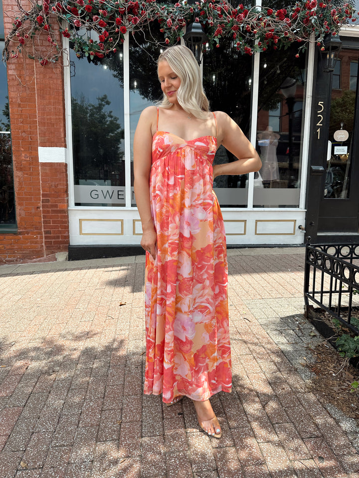 Woman wearing coral floral maxi dress with sweetheart neckline.