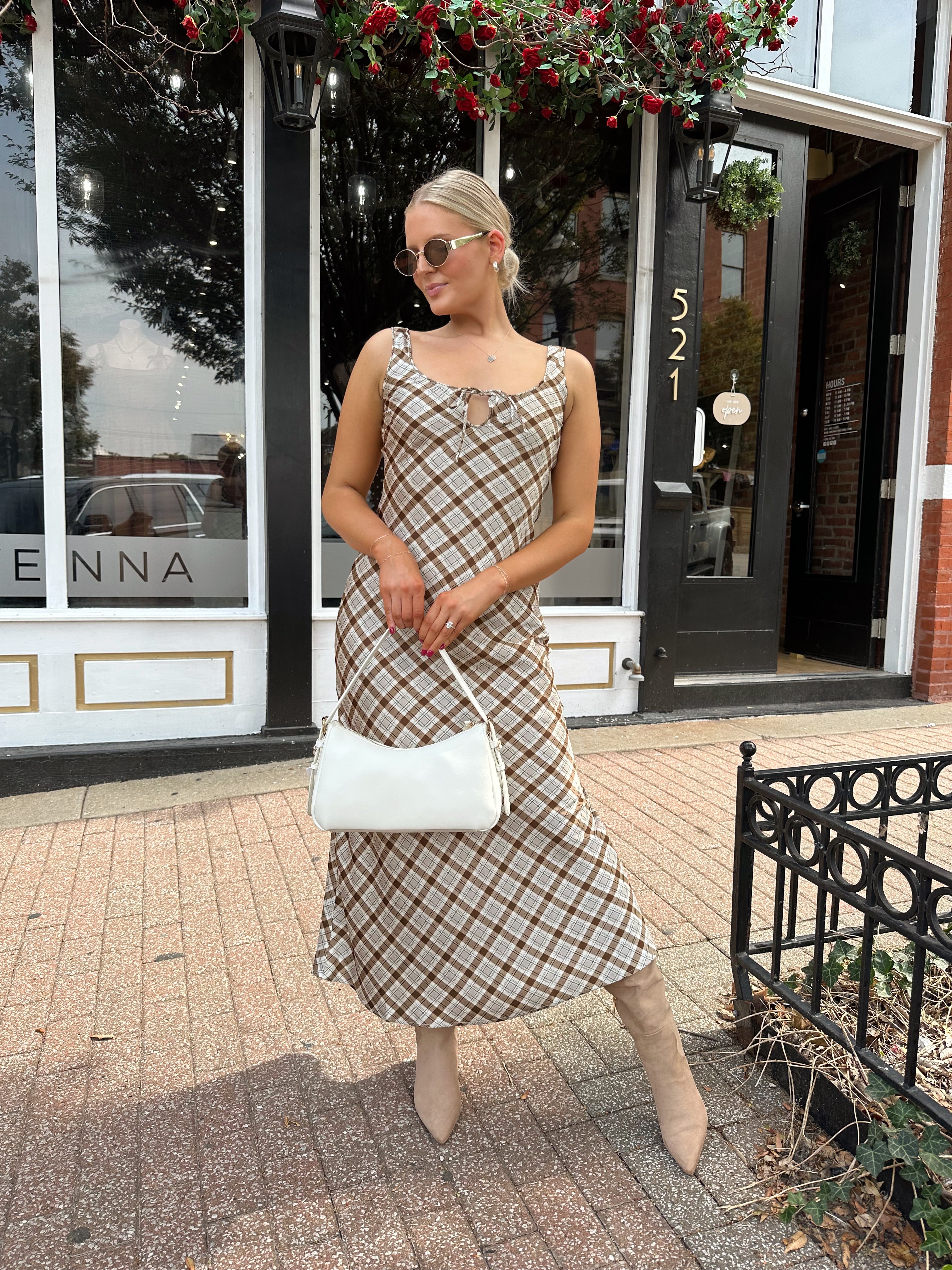 Woman wearing brown plaid satin maxi dress with keyhole tie. 
