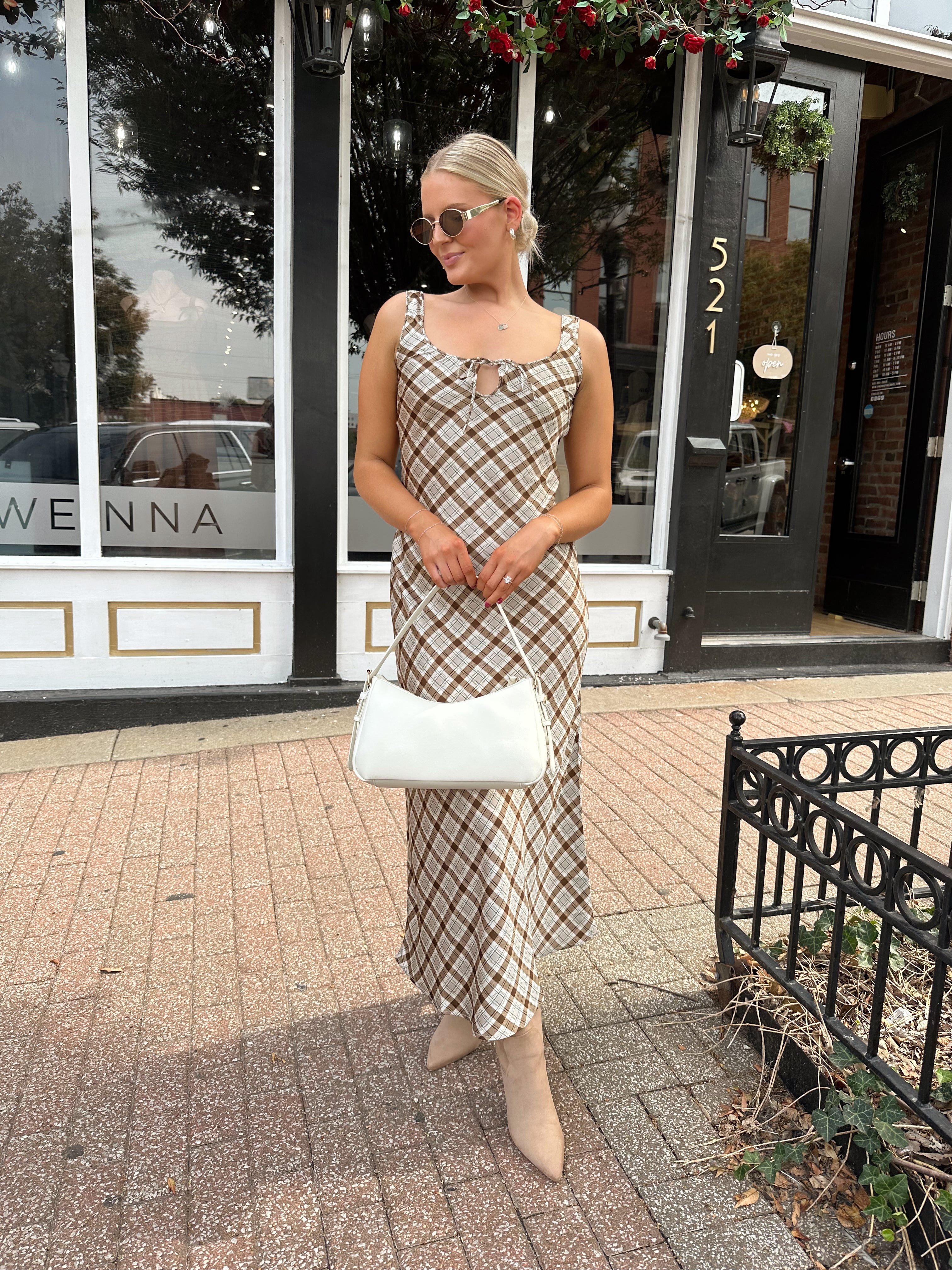 Woman wearing brown plaid satin maxi dress with keyhole tie. 