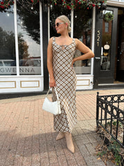 Woman wearing brown plaid satin maxi dress with keyhole tie. 