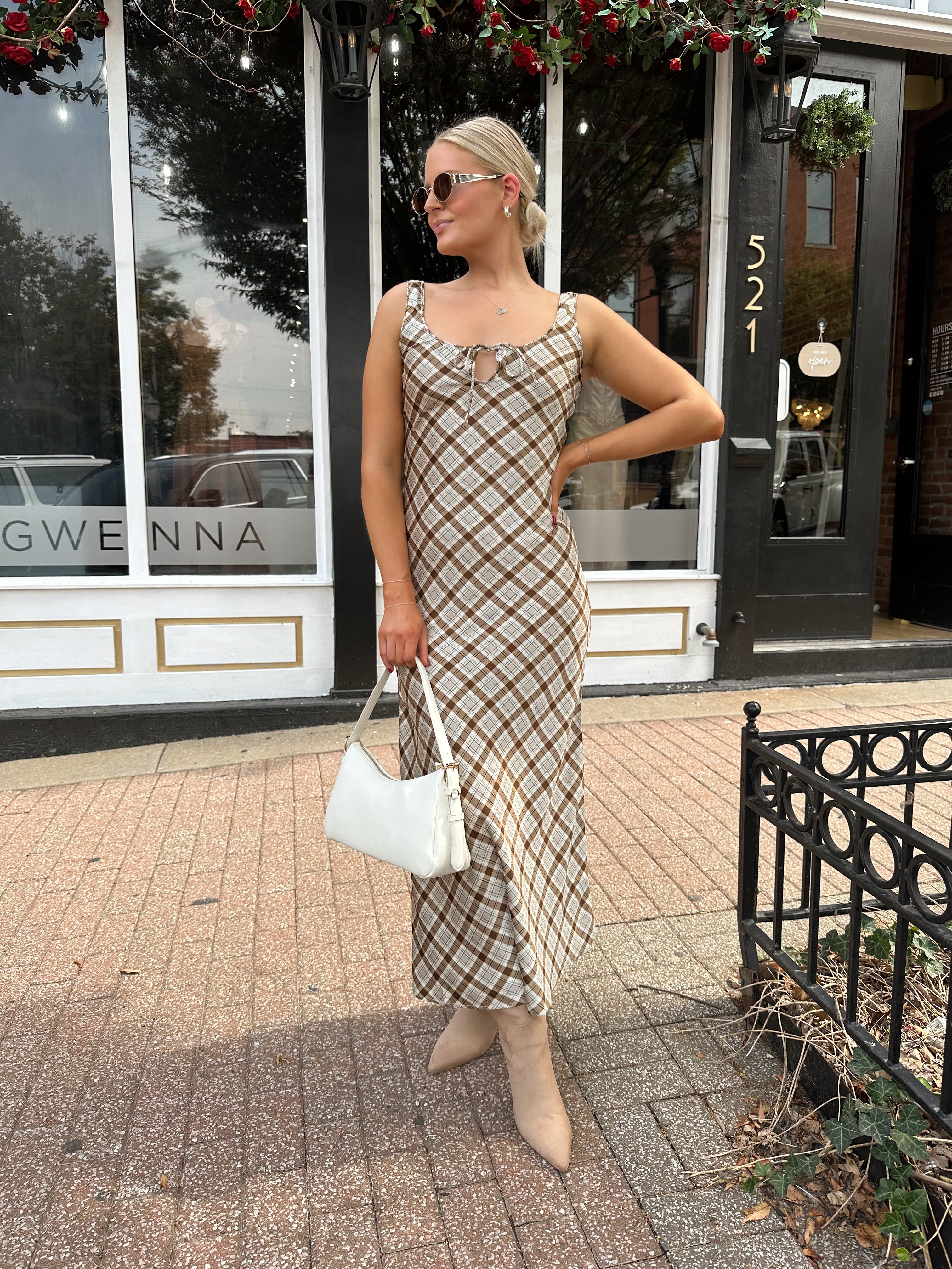 Woman wearing brown plaid satin maxi dress with keyhole tie. 