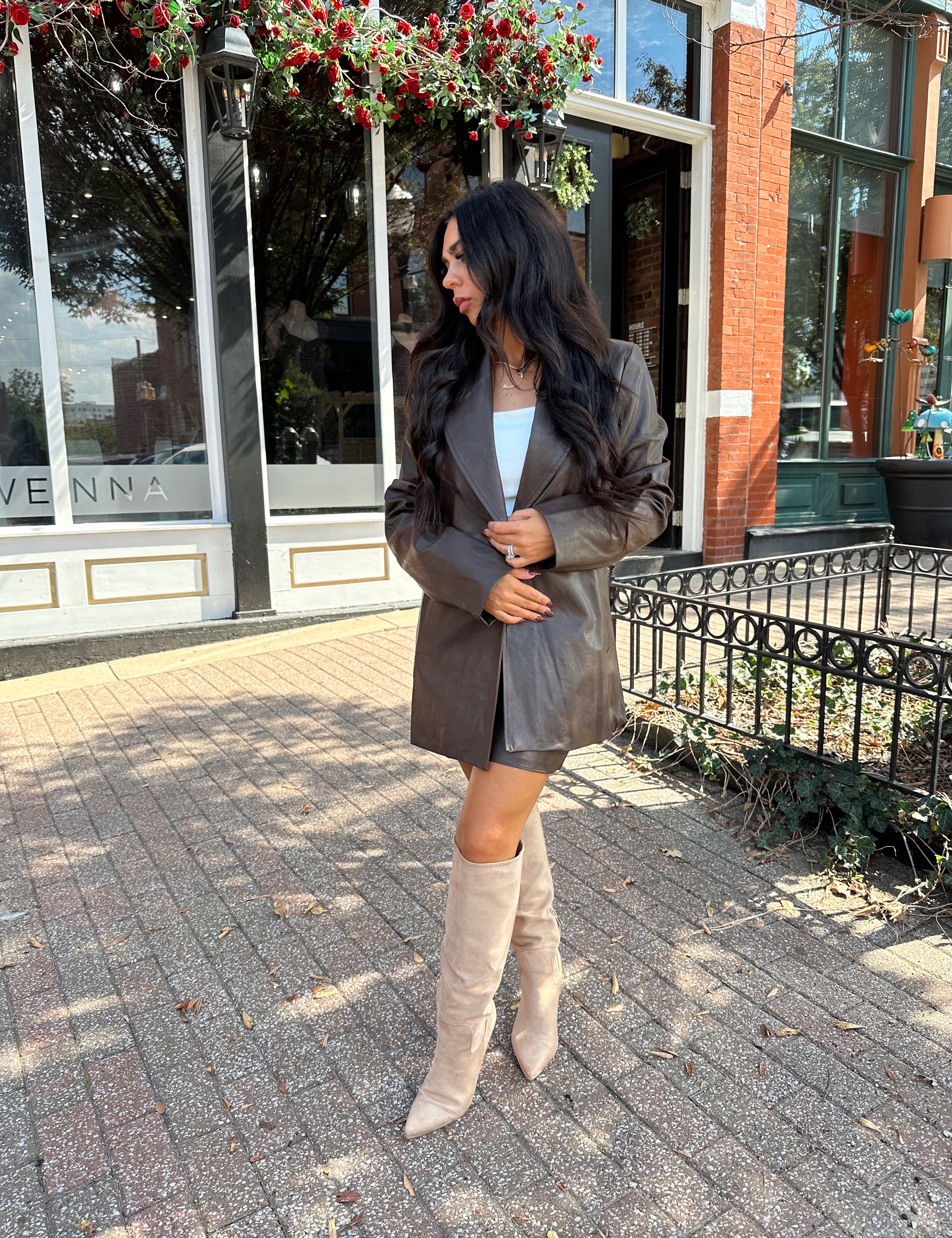 Woman wearing brown vegan leather oversized blazer. 