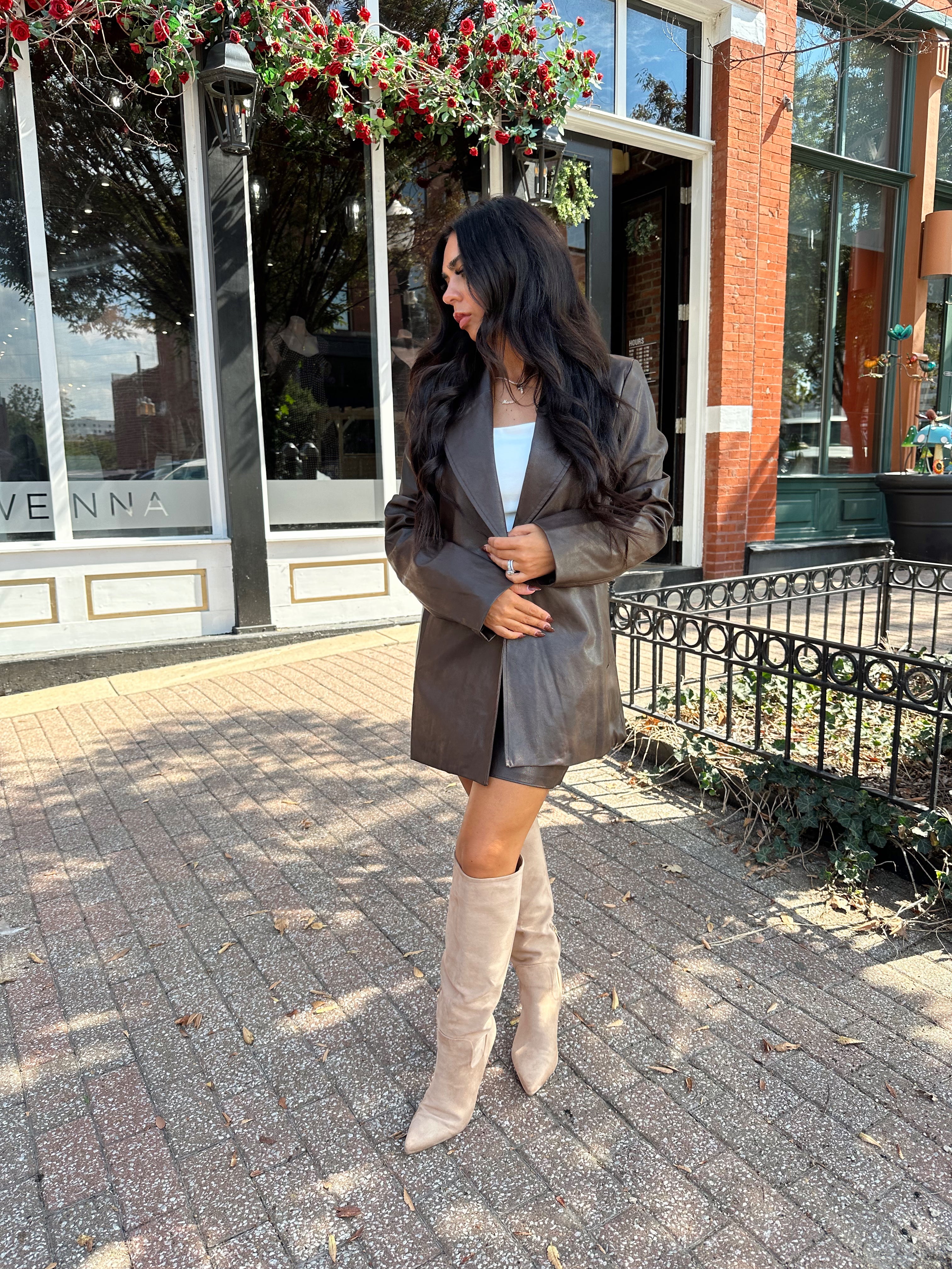 Woman wearing brown vegan leather oversized blazer. 