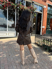 Woman wearing brown vegan leather oversized blazer. 