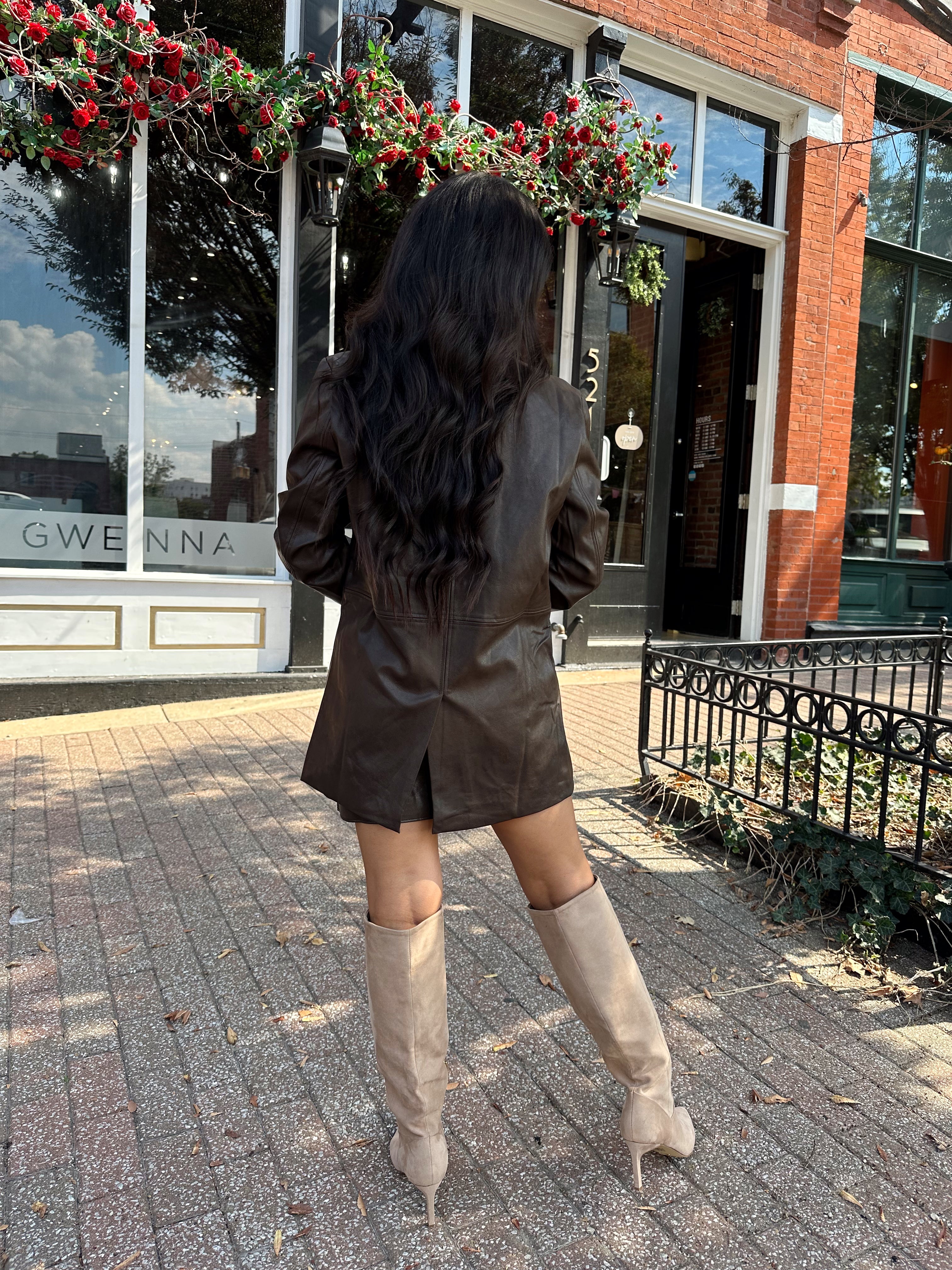 Woman wearing brown vegan leather oversized blazer. 