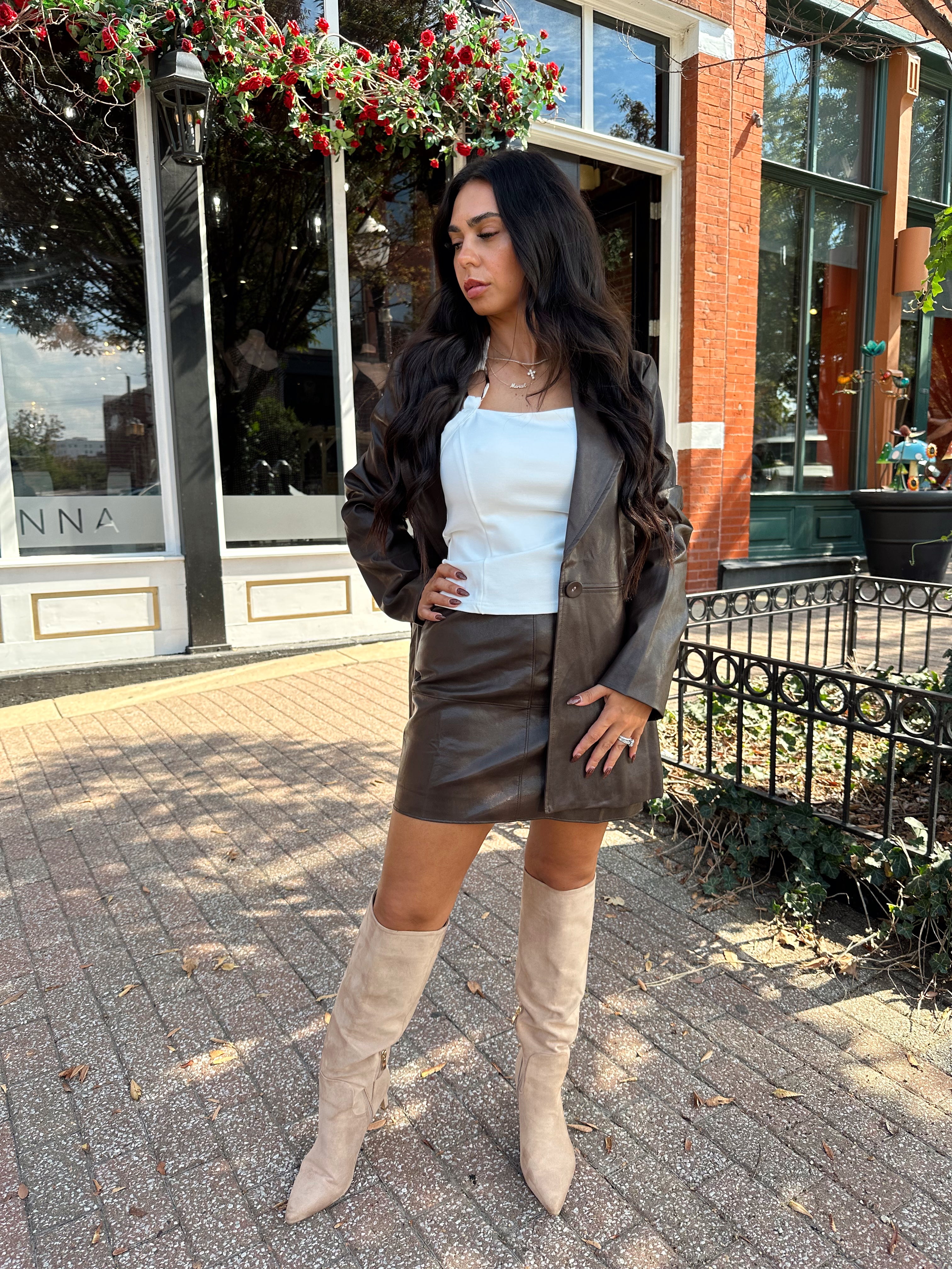 Woman wearing brown vegan leather oversized blazer. 