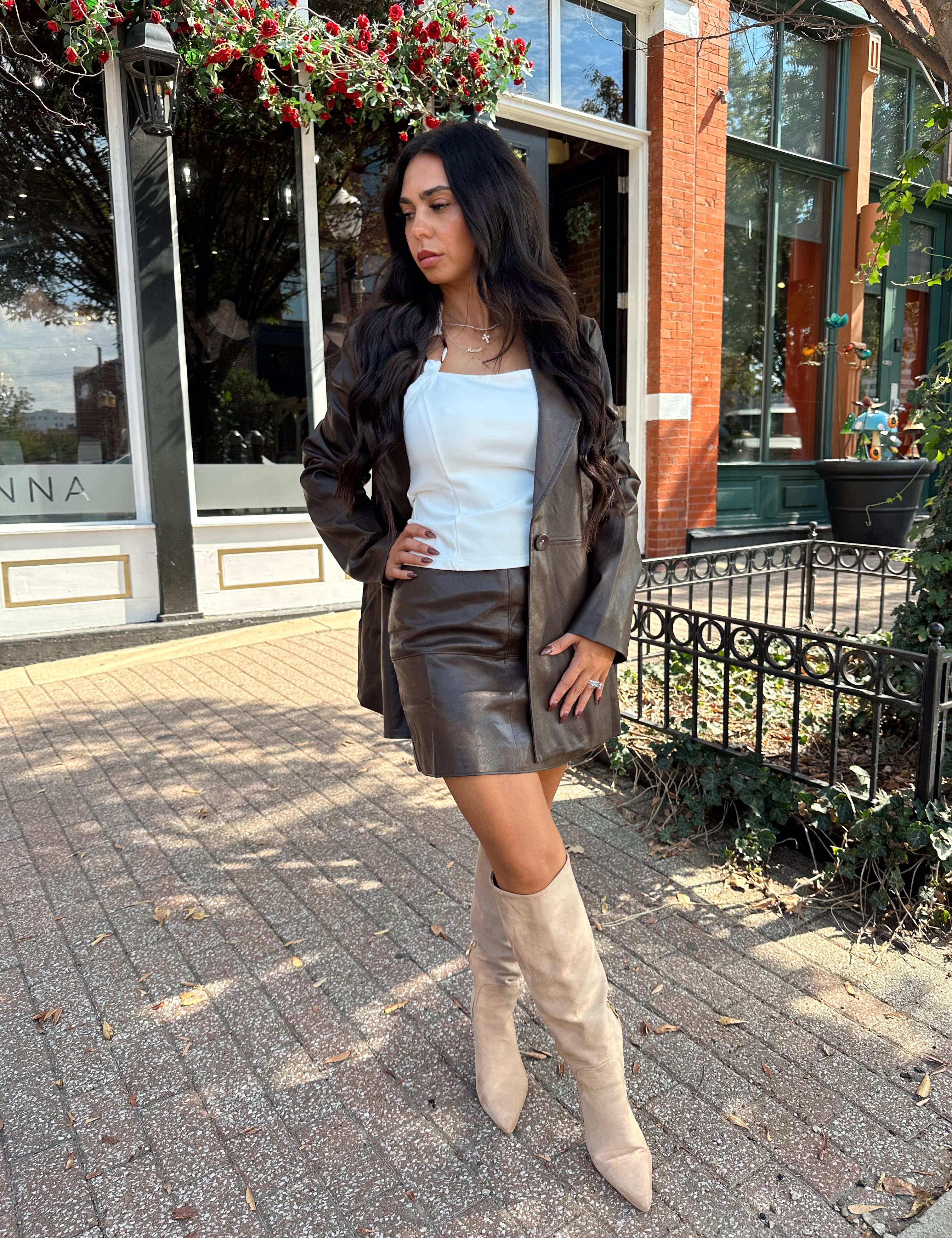 Woman wearing brown vegan leather oversized blazer. 