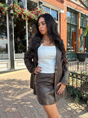 Woman wearing brown vegan leather oversized blazer. 