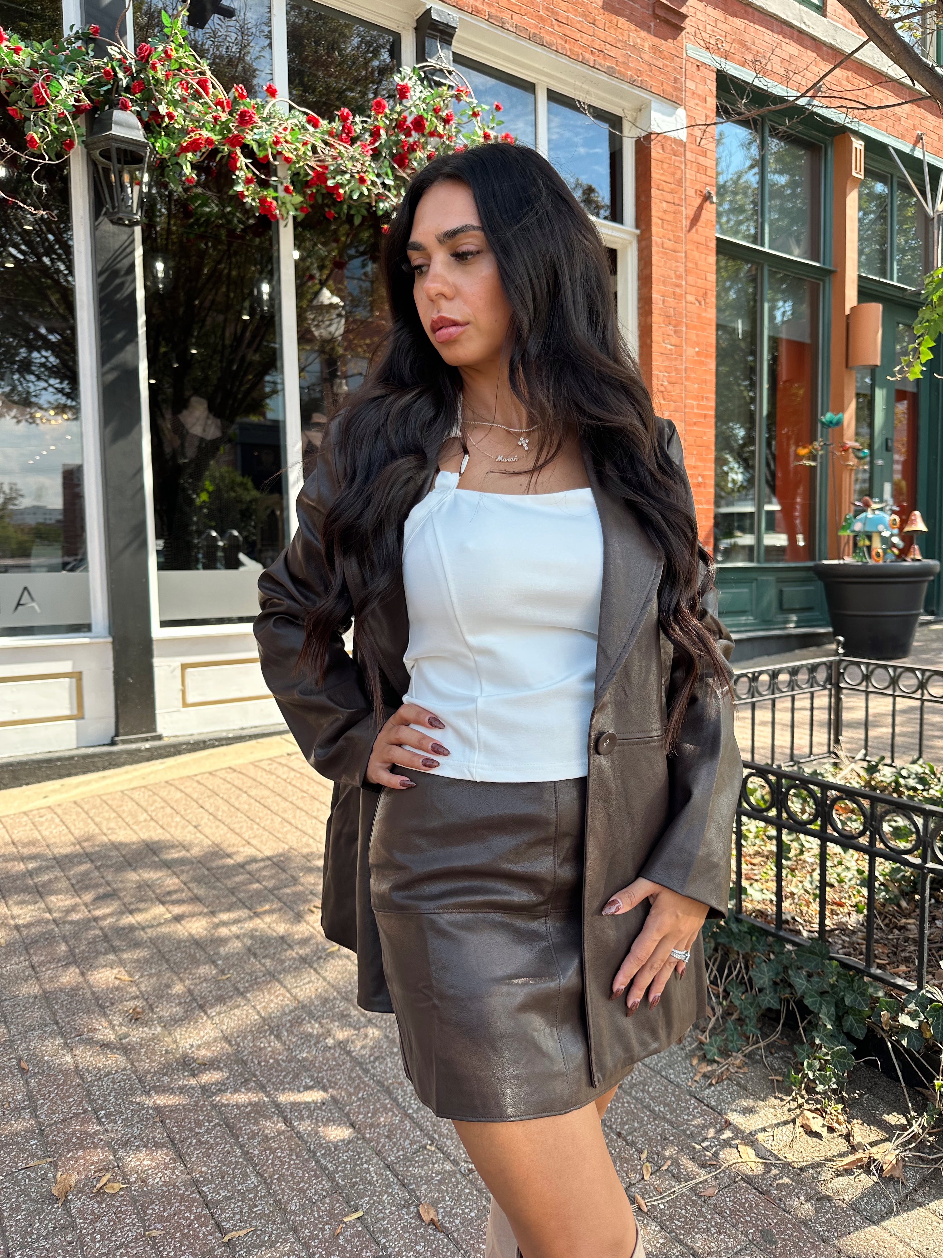 Woman wearing brown vegan leather oversized blazer. 