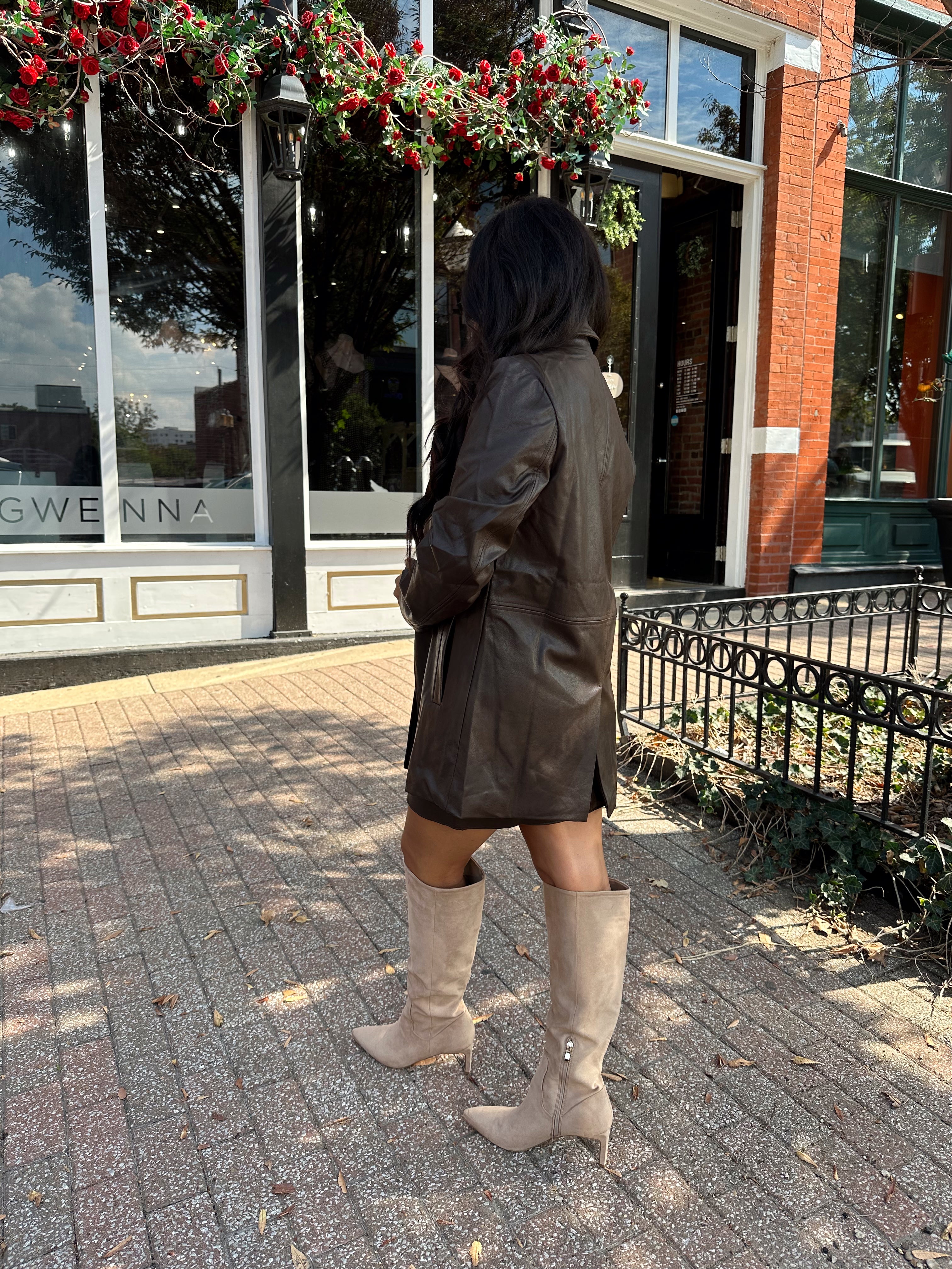 Woman wearing brown vegan leather oversized blazer. 