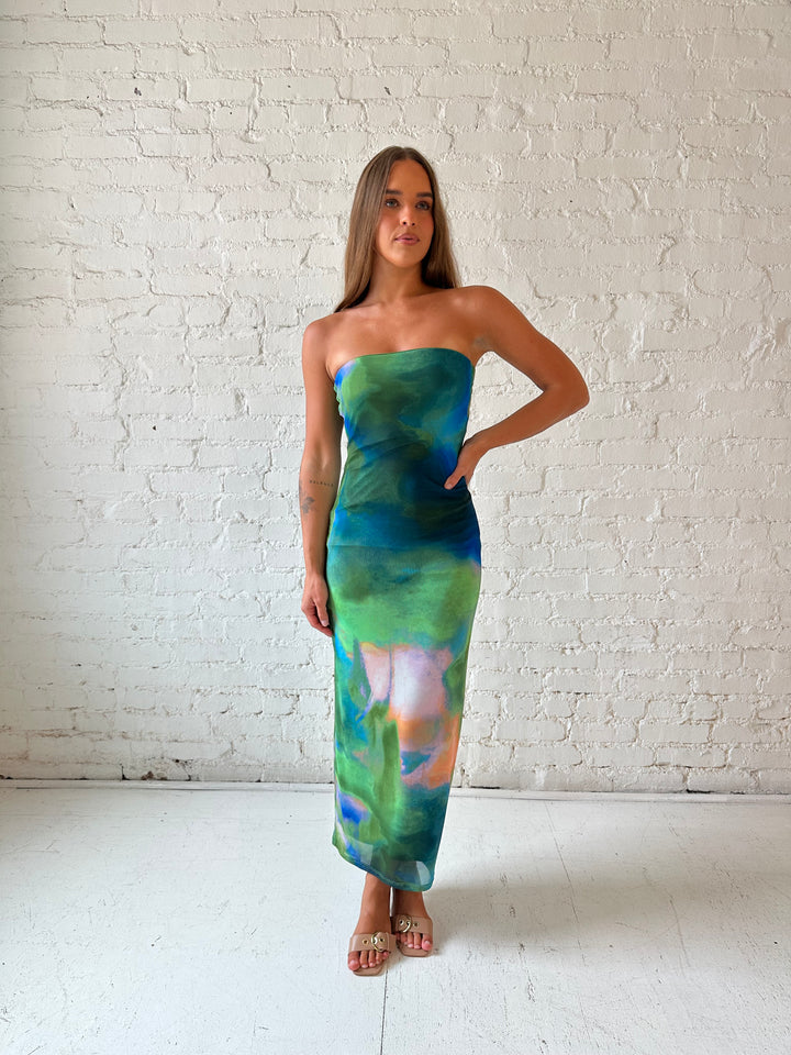 Woman wearing green watercolor pattern tube style midi dress.
