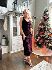 Woman wearing burgundy floral velvet midi dress with cowl neckline. 