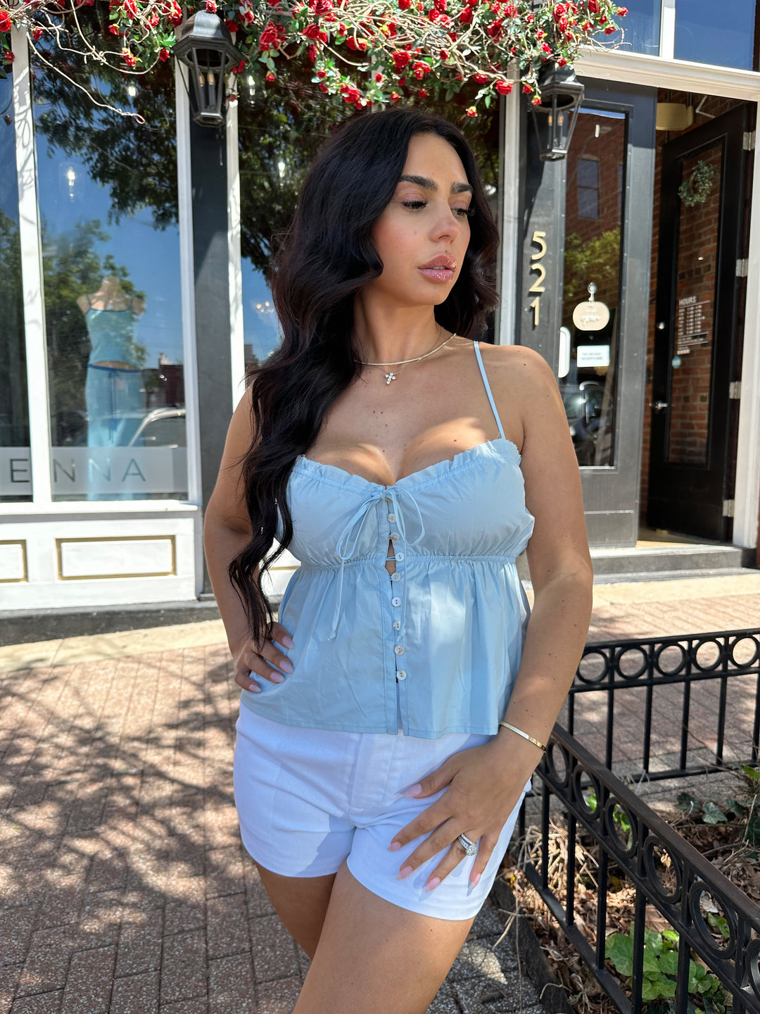 Woman wearing blue peplum tank top with white micro shorts. 