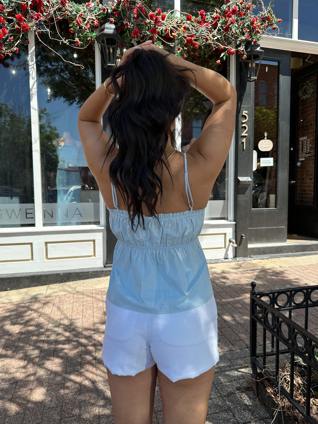 Woman wearing blue peplum tank top with white micro shorts. 
