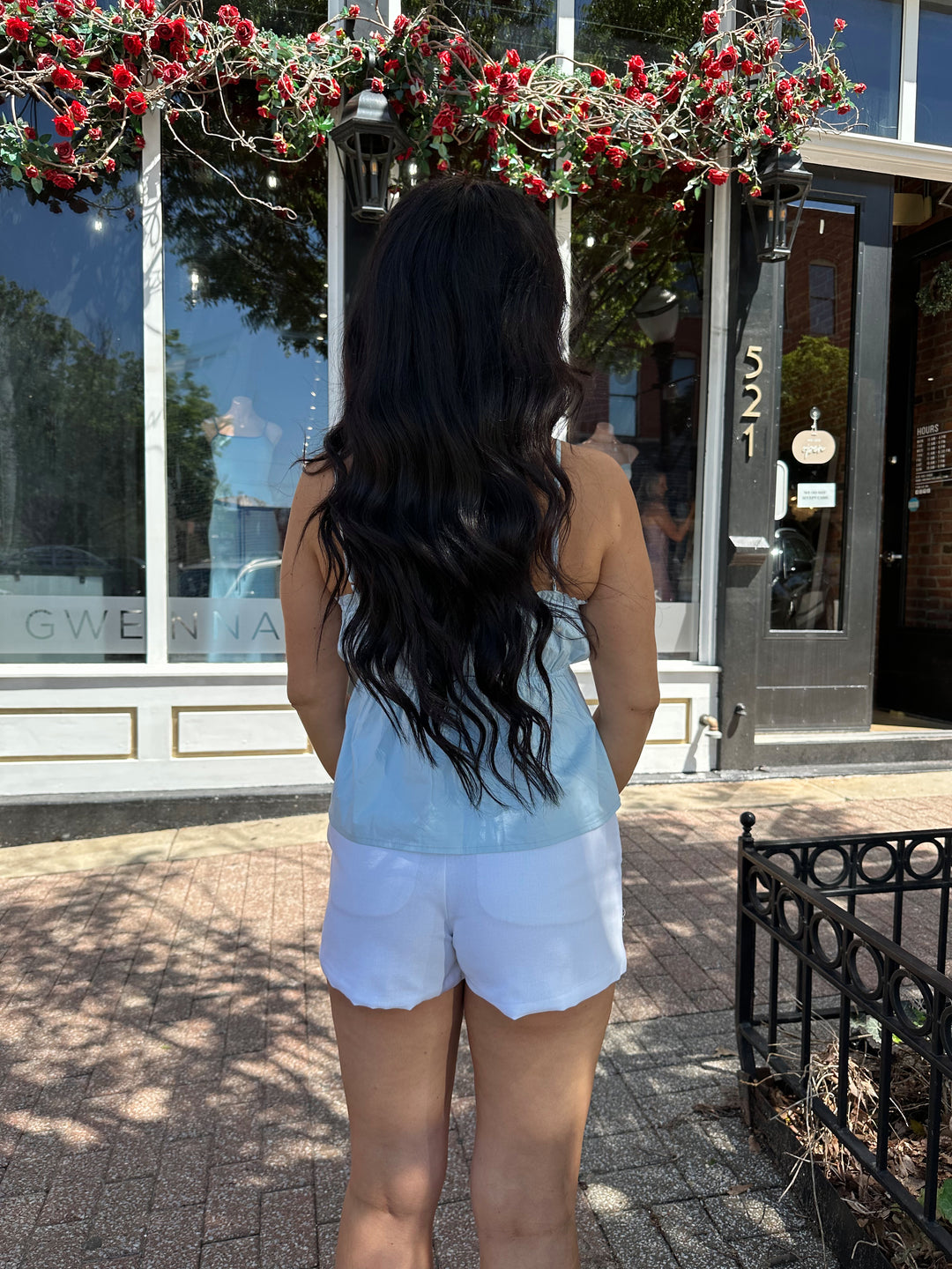 Woman wearing blue peplum tank top with white micro shorts. 