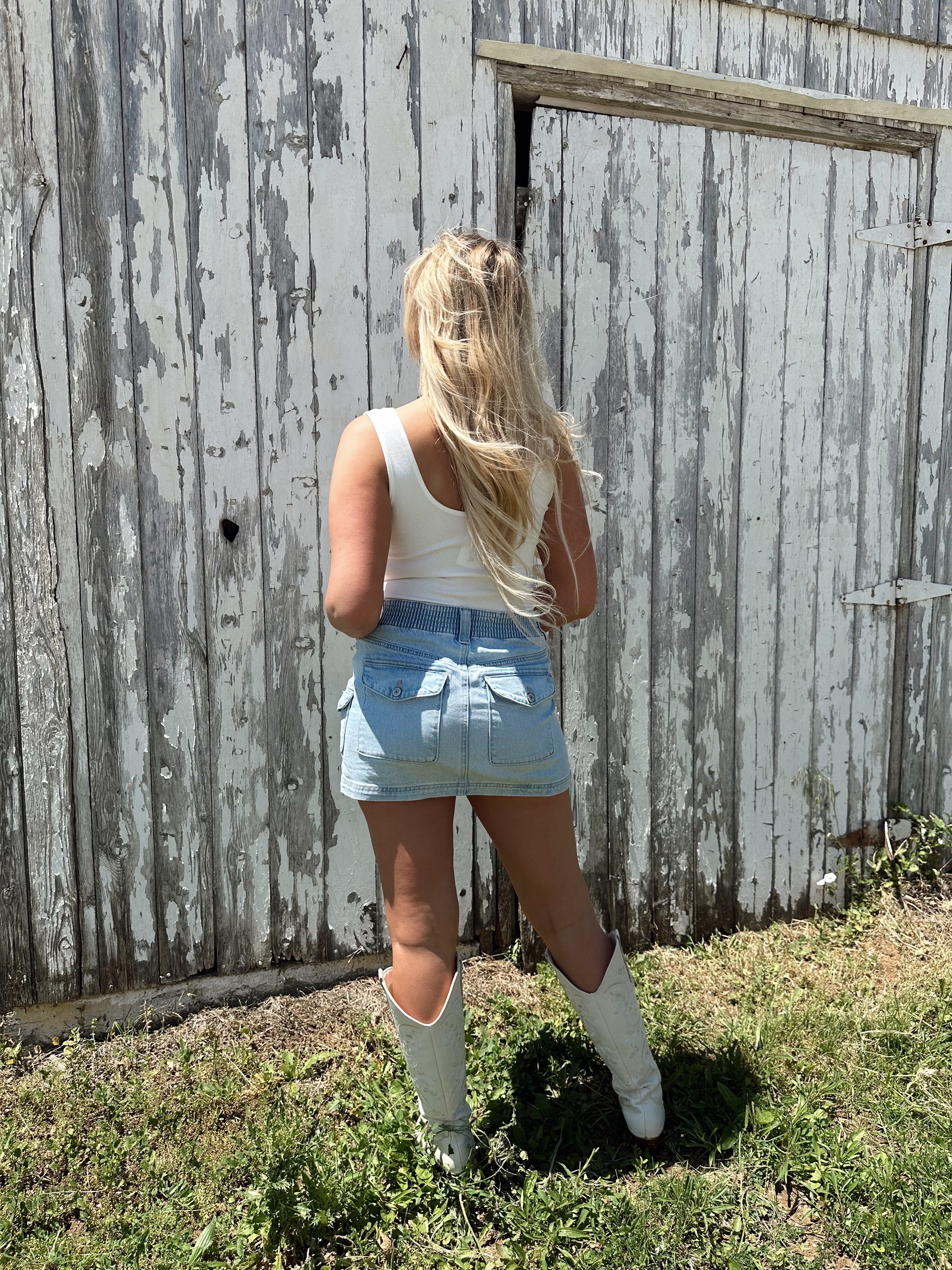 Woman in a white sleeveless bodysuit with “USA” and small flag embroidered on the chest