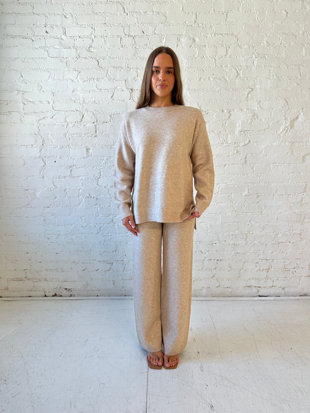 Woman wearing oatmeal colored two piece sweater set with kitten heel.