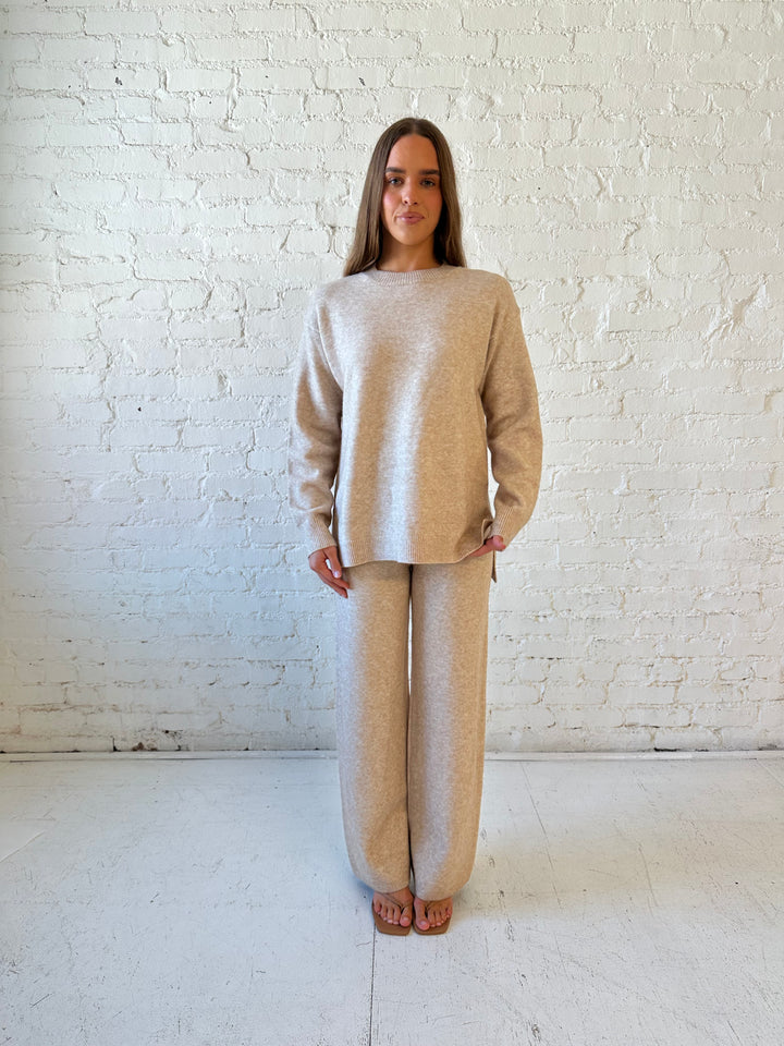 Woman wearing oatmeal colored two piece sweater set with kitten heel.