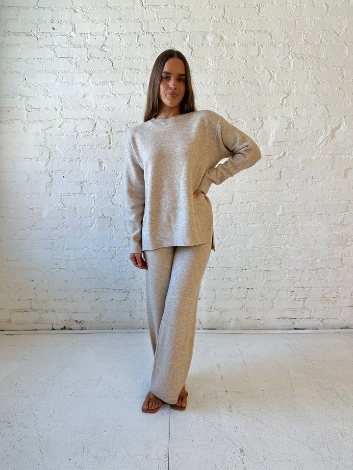 Woman wearing oatmeal colored two piece sweater set with kitten heel.