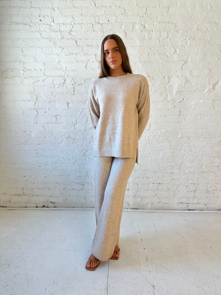 Woman wearing oatmeal colored two piece sweater set with kitten heel.