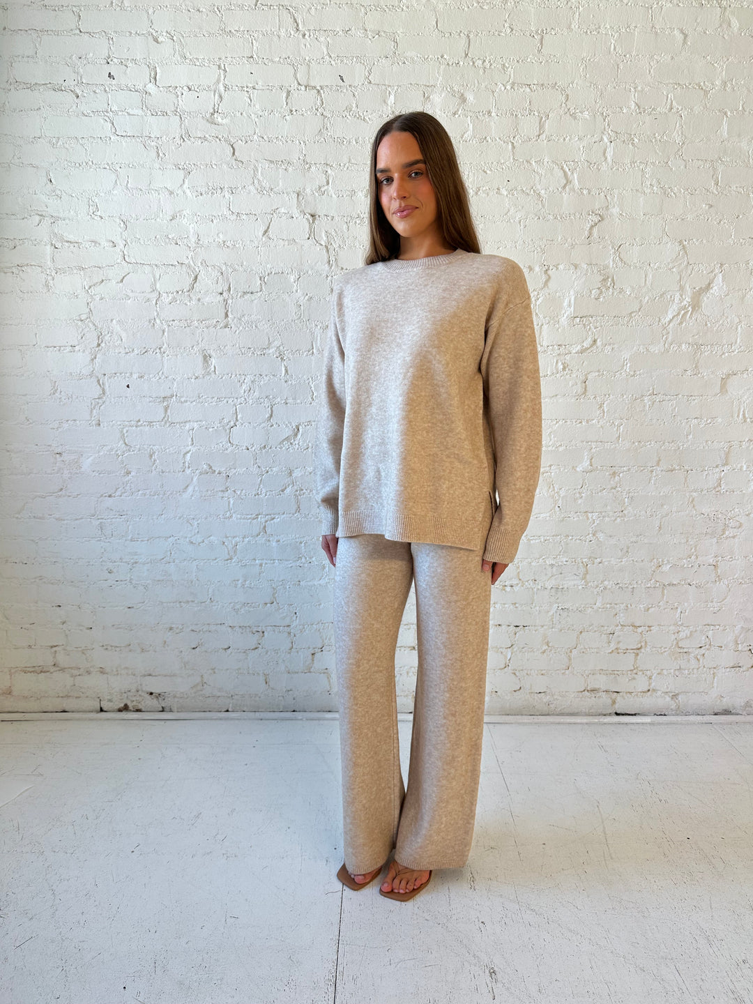 Woman wearing oatmeal colored two piece sweater set with kitten heel.