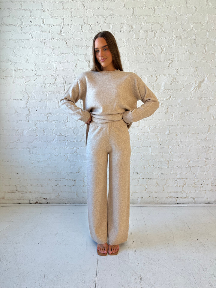 Woman wearing oatmeal colored two piece sweater set with kitten heel.