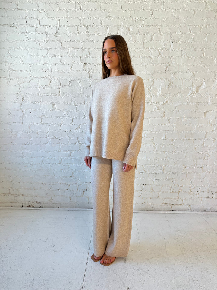 Woman wearing oatmeal colored two piece sweater set with kitten heel.