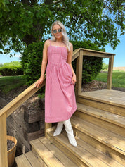 Red gingham midi dress with an open ack and adjustable spaghetti straps.