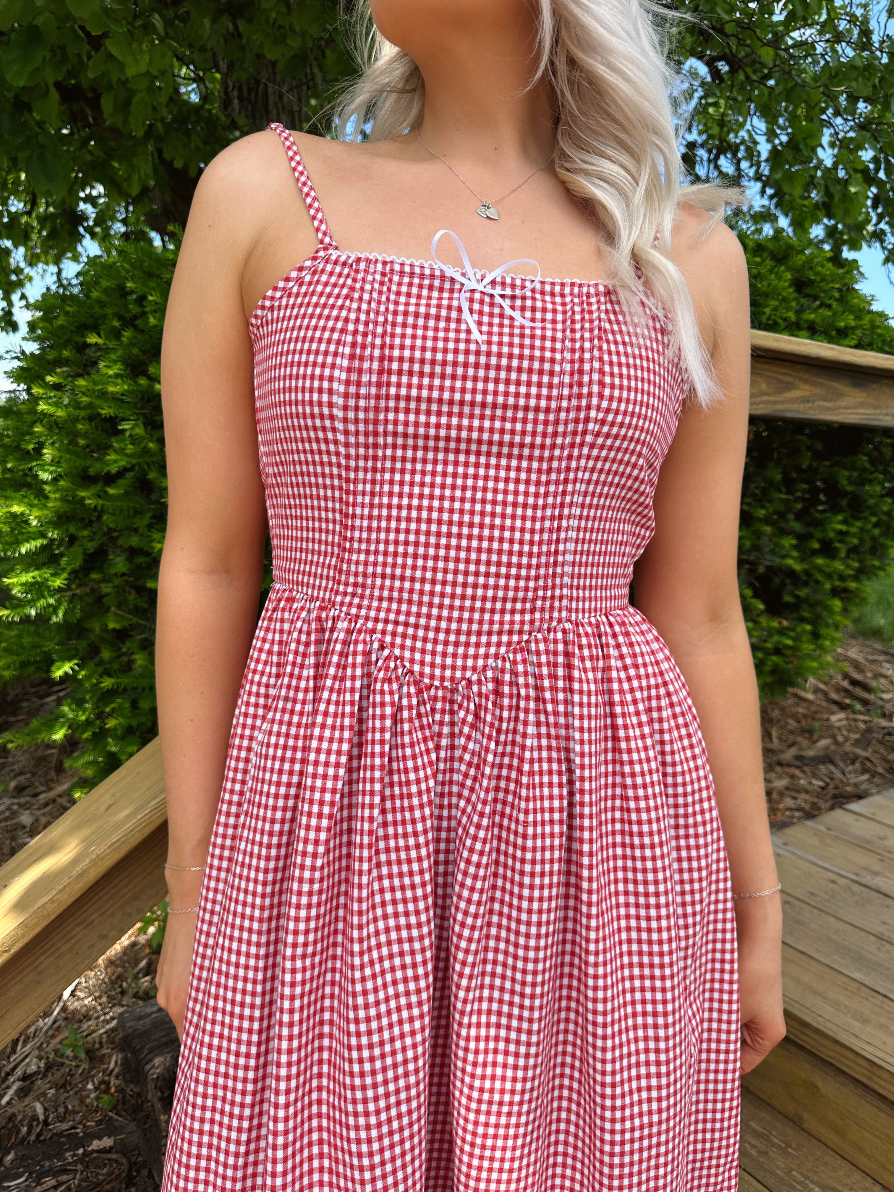Red gingham midi dress with an open ack and adjustable spaghetti straps.