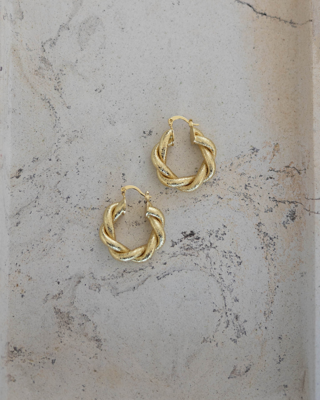 Gold plated twisted hoop earring with clasp closure. 