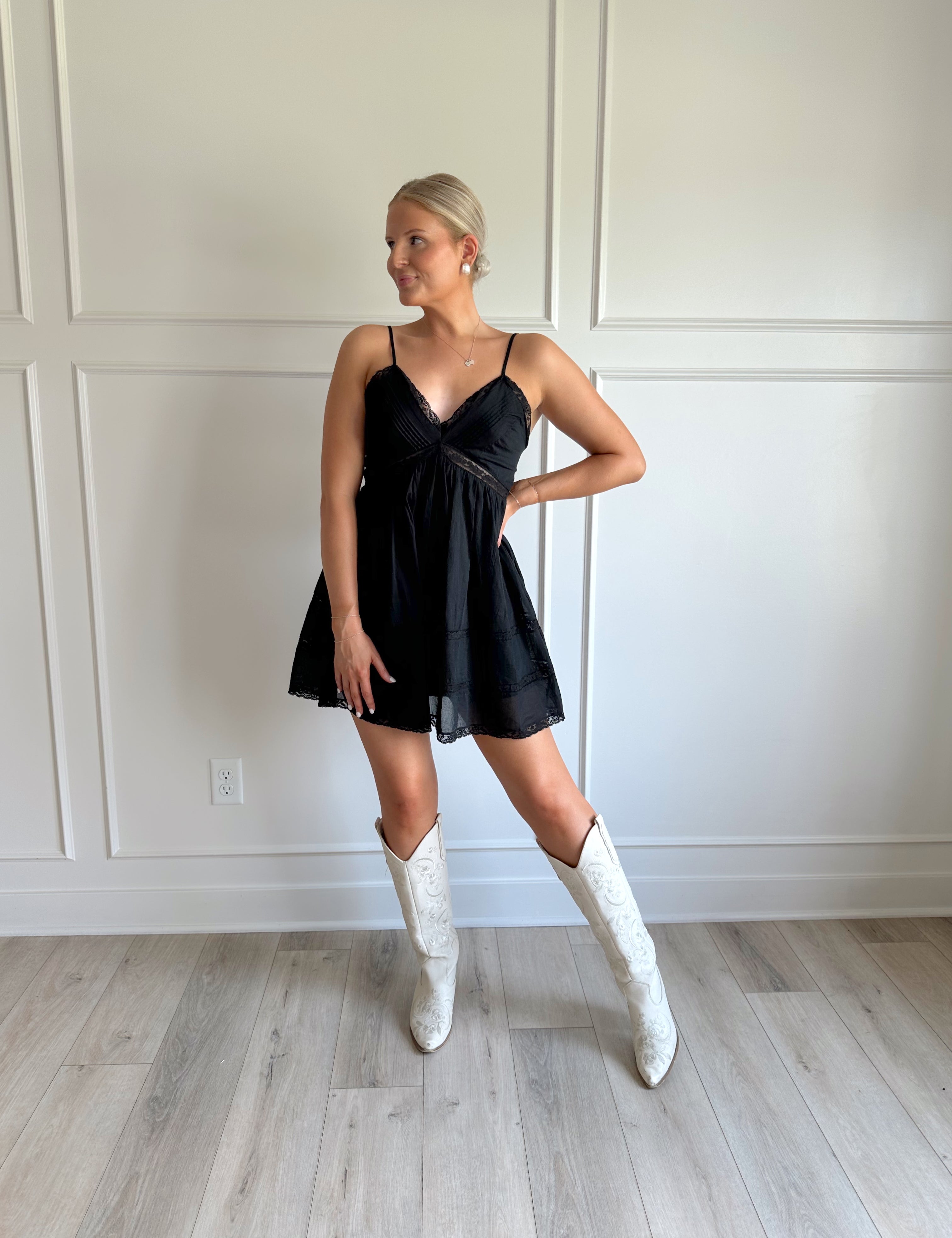 Black mini dress with lace trim detailing and adjustable straps.