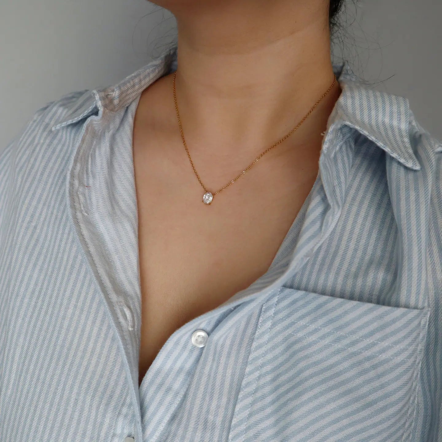 Woman wearing the Oval Zirconia Solitaire Gold Plated Necklace.