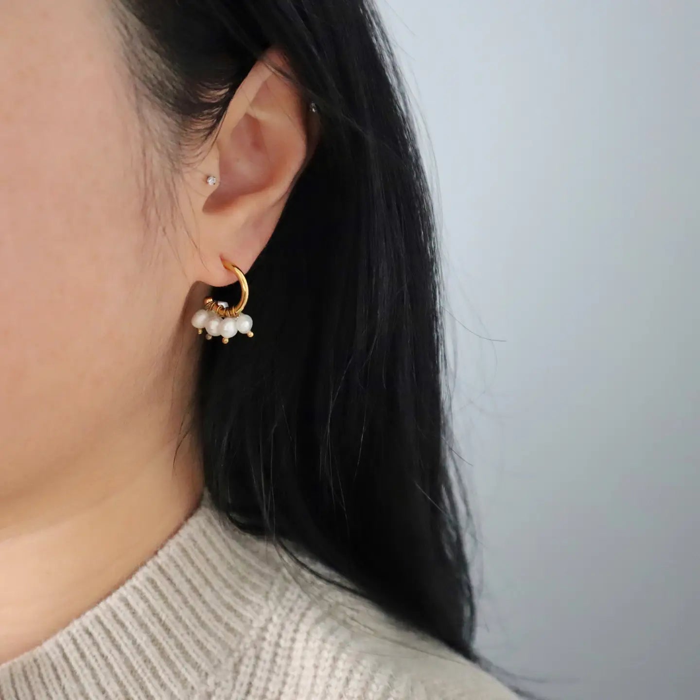 Woman wearing the Liv Dainty Pearl Hoop Gold Plated Earring.