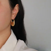 Woman wearing the Tina Textured Hoop Gold Plated Earring.